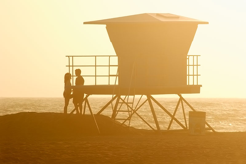 Couple About to Share a Romantic Kiss Next to Lifeguard Tower at Huntington State Beach, Huntington Beach, California